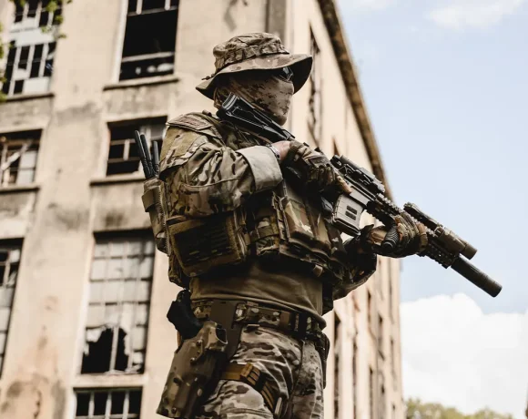 Security operator with rifle securing urban structure in high-risk environment