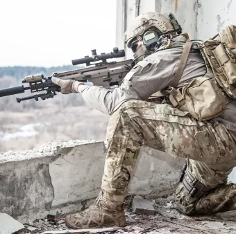 Sniper providing overwatch from elevated position in urban environment