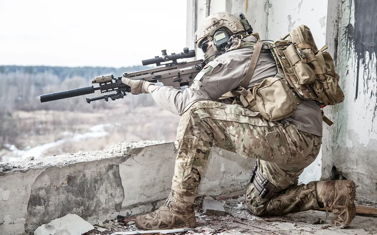 Sniper providing overwatch from elevated position in urban environment