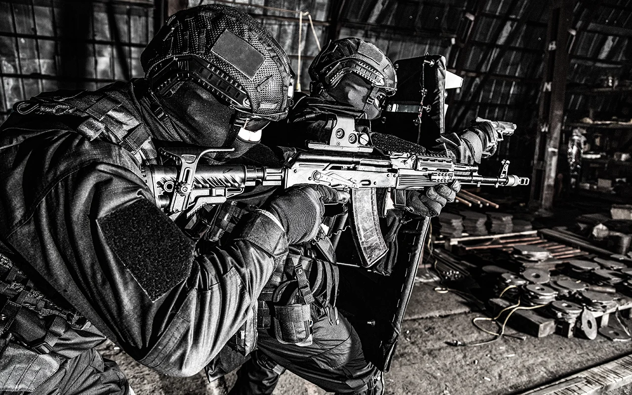 Tactical security team conducting close-quarters entry operation with ballistic shield