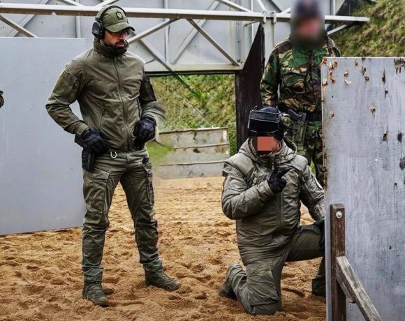 Security instructor guiding tactical movement and cover techniques during live training